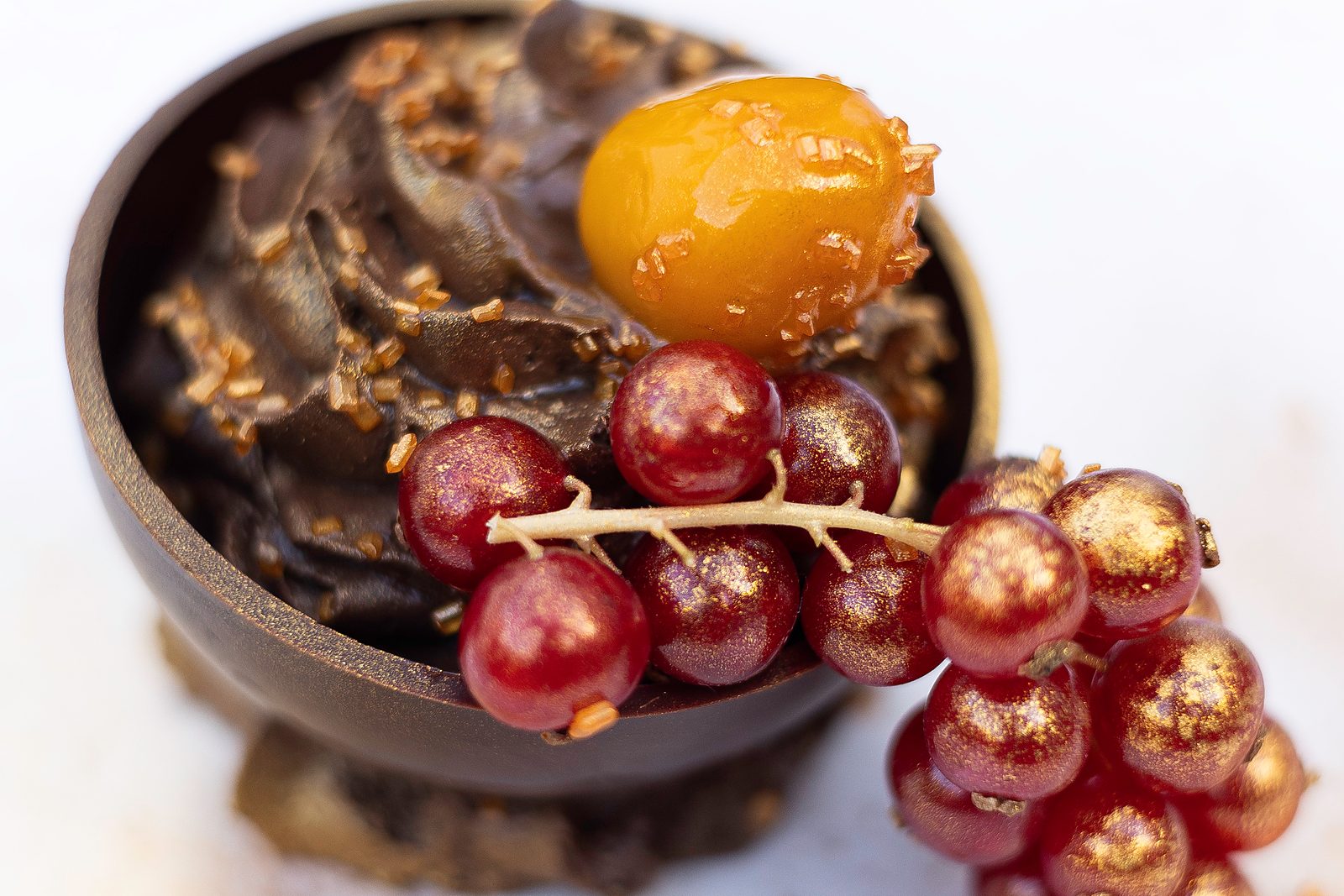 Dessert van een sitting dinner door KOM Catering: chocoladebol met mousse, abrikoos en vergulde rode bessen