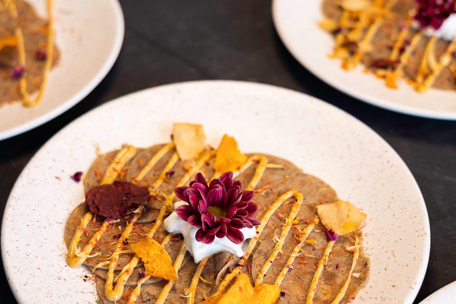 Voorgerecht van een sitting dinner door KOM Catering, uitgeserveerd op bord met eetbare bloem en chips